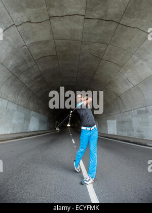 Schwarzer Mann Golfen in städtischen tunnel Stockfoto