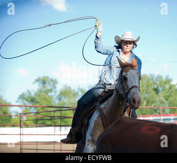 Kaukasische Cowgirl auf Pferd auf Ranch Lasso werfen Stockfoto