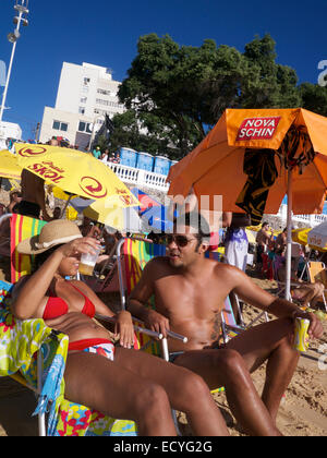 SALVADOR, Brasilien - 13. Oktober 2013: Lokale Brasilianer entspannen Sie an einem hellen Sommernachmittag am Porto da Barra Strand. Stockfoto