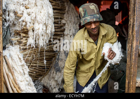 Ein Mann streckt Baumwolle in die massive Mercato von Addis Abeba, Äthiopien Stockfoto