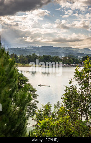 Dramatischer Himmel, Wolken und Sonnenlicht leuchtenden See Poso in Zentral-Sulawesi, Indonesien. Fischer traditionellen Kanu schweben. Stockfoto