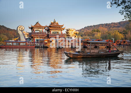 Hangzhou, China - 5. Dezember 2014: Traditionelle chinesische hölzerne Freizeit Boot mit Touristen und Bootsmann schwimmt auf dem Westsee Stockfoto