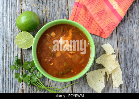 Tortilla Suppe mit Pommes Frites und frische Limette auf rustikalen Holz-Hintergrund Stockfoto