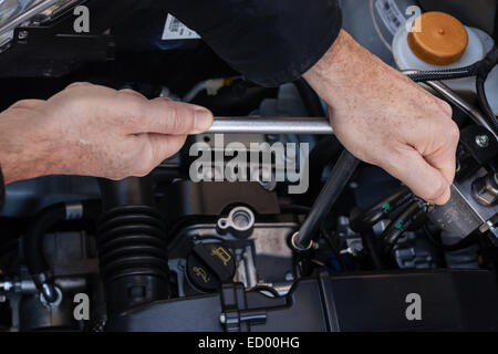 Hände, die Reparatur der Motor eines Autos mit einem Schraubenschlüssel Stockfoto