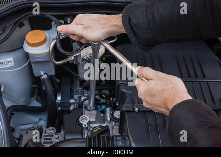 Hände, die Reparatur der Motor eines Autos mit einem Schraubenschlüssel Stockfoto