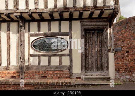 Gerahmte Fachwerkbau mit Oval geformte verbleiten Fenster und solide Holztür. Stockfoto