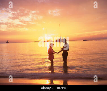 Paar im Meer bei Sonnenuntergang, Negril Beach, Negril, Westmoreland Parish, Jamaika, große Antillen, Karibik Stockfoto