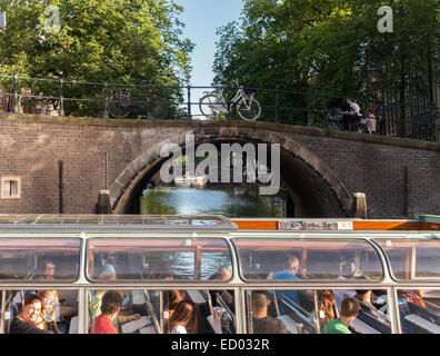 Amsterdamer Grachten. Die sieben Brücken der Reguliersgracht von einer Kanalrundfahrt mit Touristen im Herengracht-Kanal aus gesehen Stockfoto