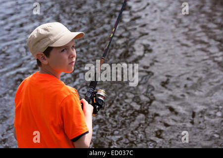 Ein kleiner Junge, Angeln in den Mühlenteich auf dem Menomonee River in Wisconsin Stockfoto