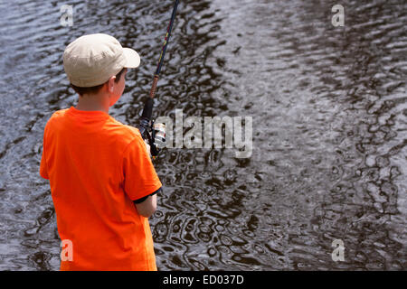 Ein kleiner Junge, Angeln in den Mühlenteich auf dem Menomonee River in Wisconsin Stockfoto