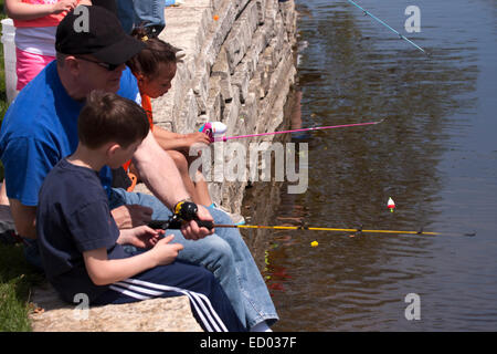 Familien, die Fischerei in einem Mühlenteich in Menomonee Falls auf ein Community-Event für Kinder Angeln-Derby Wettbewerb Stockfoto