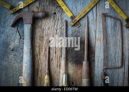 Hammer, Schraubendreher, Handsäge und Maßband auf rustikalen Holz Hintergrund Stockfoto