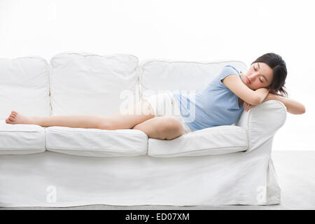 Junge Frau auf Schlafcouch Stockfoto