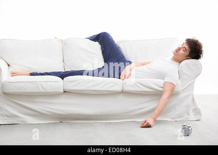 Junger Mann auf Schlafcouch Stockfoto