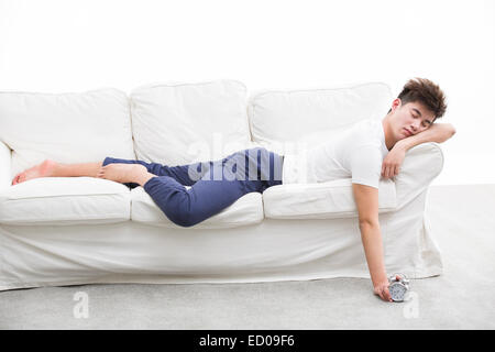 Junger Mann auf Schlafcouch Stockfoto