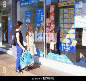 Junge Frauen betrachten Reisebüros Fenster, Bracknell, Berkshire, England, Vereinigtes Königreich Stockfoto