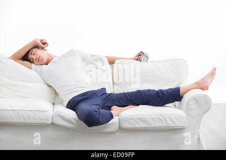 Junger Mann auf Schlafcouch Stockfoto