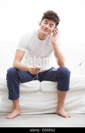Junger Mann anhören von Musik auf Smartphone Stockfoto