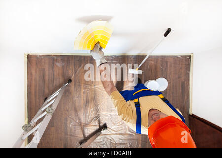 Arbeiter ist die Wahl der richtigen Farbe vor, die Wand zu malen. Stockfoto