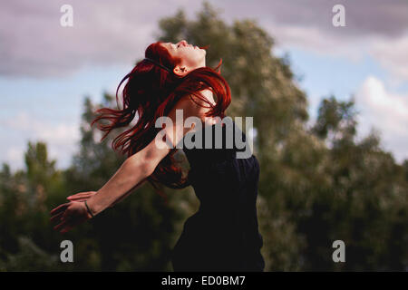 Porträt der Rotschopf Frau springen in der Luft Stockfoto
