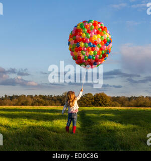 Mädchen auf einer Wiese mit einem riesigen Ballon Stockfoto