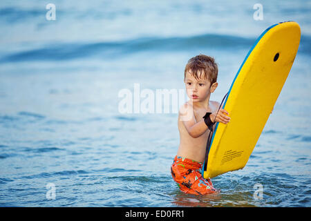 Junge stand im Meer mit einem Boogie-board Stockfoto