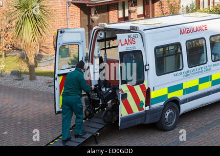 Welsh Krankenwagen NHS Trust Patiententransport Service Mann schob einen Rollstuhl Rampe vor einem Haus nach der Einnahme ein Patient Zuhause Stockfoto