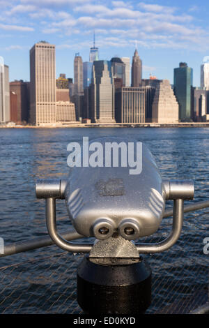 Lower Manhattan Skyline aus betrachtet der Brooklyn Bridge Park über den East River mit einer Sightseeing binokularen Maschine 17. Dezember 2014 in Brooklyn, New York. Stockfoto