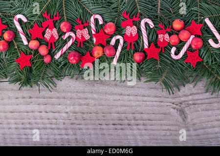 Kiefer grün, candy Canes, Äpfel und Sternen auf hölzernen Hintergrund Stockfoto