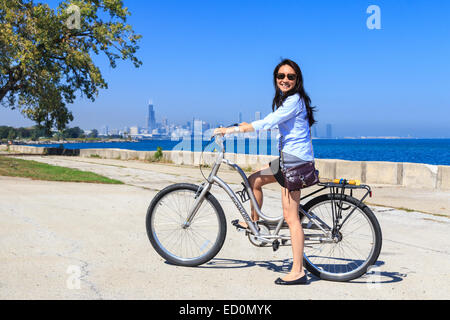 Junge asiatische Frau, die ihr Fahrrad am Lake Michigan in der South Side von Chicago, IL, USA. Stockfoto