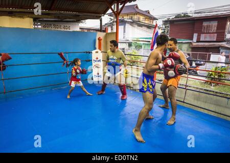 Bangkok, Bangkok, Thailand. 23. Dezember 2014. Boxer-Spar und Training in der Turnhalle der Kanisorn in Bangkok. Die Kanisorn-Box-Gym gibt einen kleinen Fitnessraum entlang der Wong Wian Yai - Samut Sakhon Bahngleisen. Junge Menschen aus den umliegenden Gemeinden kommen in die Turnhalle, Thai-Boxen zu lernen. Muay Thai (Muai Thai) ist eine gemischte Kampfkunst in Thailand entwickelt. Muay Thai wurde international im zwanzigsten Jahrhundert, als Thai-Boxer andere bekannte Boxer besiegt weit verbreitet. Eine professionelle Liga richtet sich nach der World Muay Thai Council. Muay Thai gilt häufig als Weg aus der Armut für junge Thais. MUA Stockfoto