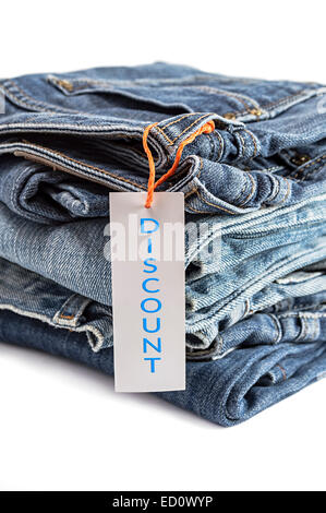 Haufen von Blue Jeans mit Label isoliert auf weißem Hintergrund. Selektiven Fokus auf Tag-Etikett. Stockfoto