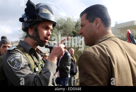 Bethlehem, West Bank. 23. Dezember 2014. Eine palästinensische Demonstranten argumentiert mit Mitgliedern der israelischen Sicherheitskräfte bei einer Demonstration gegen die israelische Siedlungen und anspruchsvollen Bewegungsfreiheit für die Palästinenser in der Weihnachtszeit in der Nähe von einem Checkpoint in Bethlehem. © Muhesen Amren/APA-Images/ZUMA Draht/Alamy Live News Stockfoto