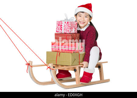 Glückliches Mädchen mit Weihnachtsgeschenken auf Schlitten Stockfoto