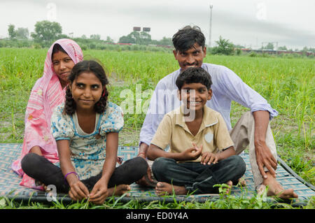 indische ländlichen Eltern und Kinder sitzen Bauernhof Stockfoto