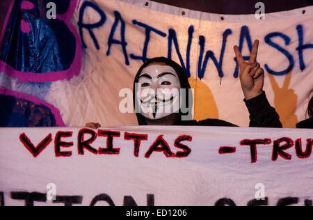 London, UK. 23. Dezember 2014. Online-Aktivismus-Gruppe Anonymous marschieren durch London von der Stadt zum Hauptquartier des BBCS auf Great Portland Street aus Protest gegen angebliche Vorurteile und Jacken ein Pädophilen-Ring. Bild: Ein Demonstrant macht die Zeichen "V for Victory" mit seinen Fingern. Bildnachweis: Paul Davey/Alamy Live-Nachrichten Stockfoto