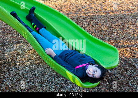 Junges Mädchen rutscht eine Rutschbahn in umgekehrter Reihenfolge Stockfoto