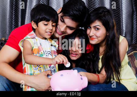 indischen Eltern mit Kindern Piggy Bank Geld sparen Stockfoto