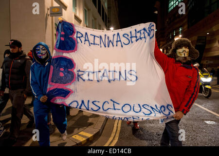 London, UK. 23. Dezember 2014. Maskierte '' Anonymous'' Mitglieder marschieren Trog London an die BBC-zentrale, den Sender für seine '' voreingenommen '' reporting und die Beherbergung von mutmaßlichen pädophilen Jimmy Savile zuzuschlagen. Untersuchung ist für den dritten Zeit- und befeuerten Spekulationen verzögert, dass der Bericht der BBC '' heftige Turbulenzen '' bereiten wird. Bildnachweis: Velar Grant/ZUMA Wire/ZUMAPRESS.com/Alamy Live-Nachrichten Stockfoto