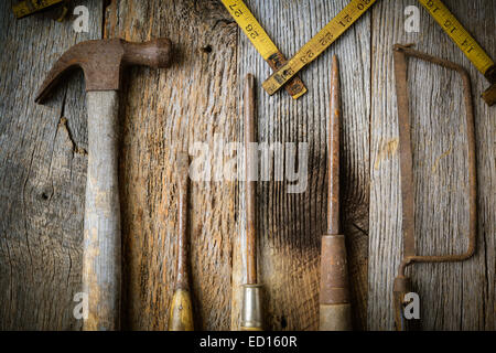 Hammer, Schraubendreher, Handsäge und Maßband auf rustikalen Holz Hintergrund Stockfoto