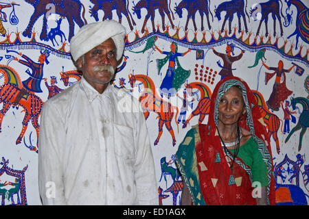 Rathwa Stammes-paar vor Pithora Malereien im Haus in der Nähe Jambughoda, Gujarat, Indien Stockfoto