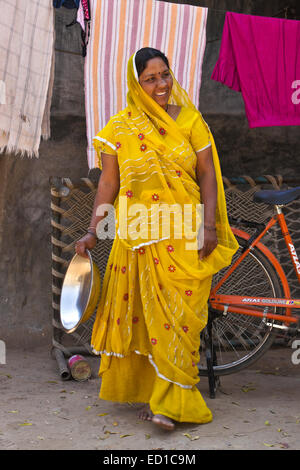 Frau in traditioneller Kleidung aufhängen von Wäsche vor ihrem Haus, Modhera, Gujarat, Indien Stockfoto