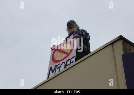 Kein Mcdonalds in Tecoma Demonstrant, einem nahe gelegenen Gebäude um ein Zeichen aus Protest gegen die Läden Bau halten erklommen Stockfoto