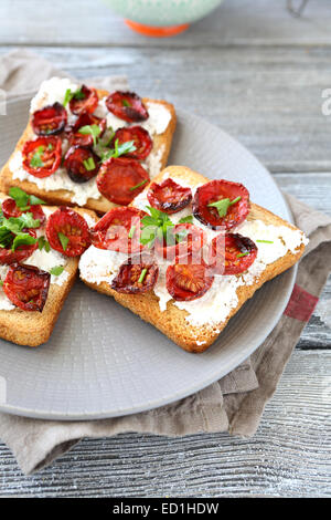 Bruschetta mit sonnengetrockneten Tomaten und Käse auf einem Teller, Essen Stockfoto