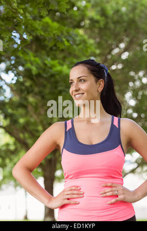 Happy fit Brünette mit den Händen auf den Hüften Stockfoto