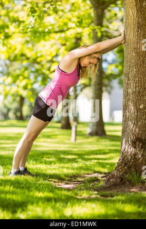 Passen Sie blonde Strecken gegen einen Baum Stockfoto