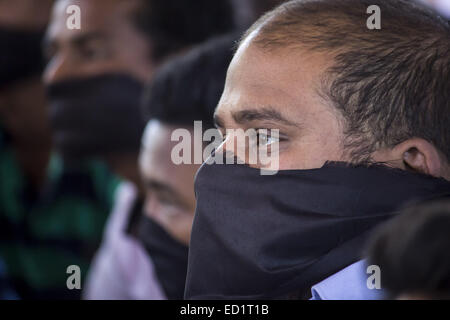 Sivasagar, Assam, Indien. 24. Dezember 2014. Indien, SIVASAGAR: Aktivisten von der alle Assam Studenten Union (AASU) binden ihre Münder mit schwarzen Klamotten während einer Sit aus Protest gegen Angriffe auf die Dorfbewohner von militanten an vier verschiedenen Orten im Sivasagar Viertel der nordöstliche Assam Zustand am 24. Dezember 2014. Mindestens intensiviert 56 Menschen, darunter Kinder starben in einer Reihe von militanten Angriffe in Assam, indische Polizei am 24. Dezember als Rebellen aus der verbotenen Nationalen Demokratischen Front der Bodoland (NDFB) dramatisch, sagte eine lang andauernde separatistischen Kampagne in den Tee-Anbau Zustand. Stockfoto