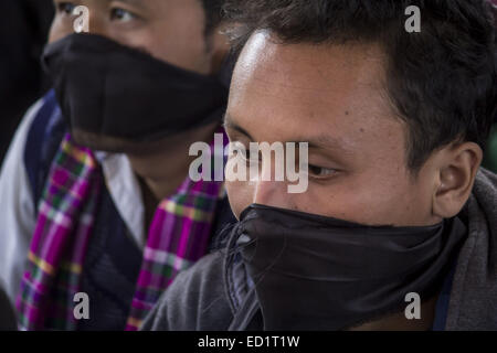 Sivasagar, Assam, Indien. 24. Dezember 2014. Indien, SIVASAGAR: Aktivisten von der alle Assam Studenten Union (AASU) binden ihre Münder mit schwarzen Klamotten während einer Sit aus Protest gegen Angriffe auf die Dorfbewohner von militanten an vier verschiedenen Orten im Sivasagar Viertel der nordöstliche Assam Zustand am 24. Dezember 2014. Mindestens intensiviert 56 Menschen, darunter Kinder starben in einer Reihe von militanten Angriffe in Assam, indische Polizei am 24. Dezember als Rebellen aus der verbotenen Nationalen Demokratischen Front der Bodoland (NDFB) dramatisch, sagte eine lang andauernde separatistischen Kampagne in den Tee-Anbau Zustand. Stockfoto