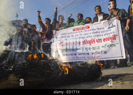 Sivasagar, Assam, Indien. 24. Dezember 2014. Indien, SIVASAGAR: Aktivisten der Asom Jatiyatabadi Yuba Charta Parishad (AJYCP) brennen das Bildnis von Assam Ministerpräsident Tarun Gogoi aus Protest gegen Angriffe auf die Dorfbewohner von militanten an vier verschiedenen Orten im Sivasagar Viertel der nordöstliche Assam Zustand am 24. Dezember 2014. Stockfoto