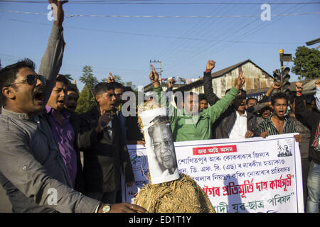 Sivasagar, Assam, Indien. 24. Dezember 2014. Indien, SIVASAGAR: Aktivisten der Asom Jatiyatabadi Yuba Charta Parishad (AJYCP) brennen das Bildnis von Assam Ministerpräsident Tarun Gogoi aus Protest gegen Angriffe auf die Dorfbewohner von militanten an vier verschiedenen Orten im Sivasagar Viertel der nordöstliche Assam Zustand am 24. Dezember 2014. Stockfoto